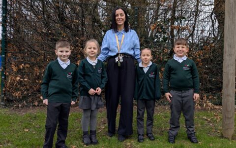 Rebecca stood with four children against wooded background