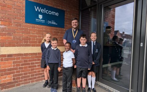 Children and principal smiling